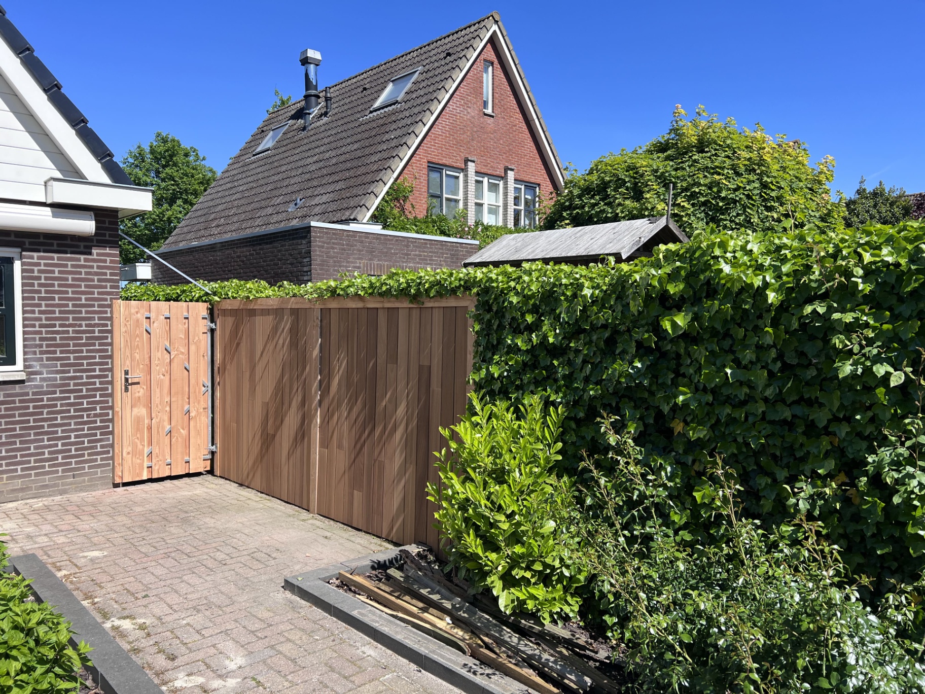 Schutting met verborgen toegangsdeur naast de tuinkamer