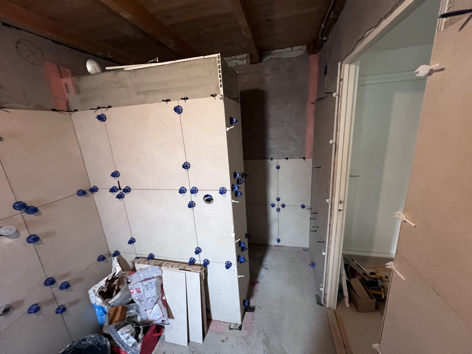 Tegels op de wand uitgezet zodat alle voegen rondom doorlopen