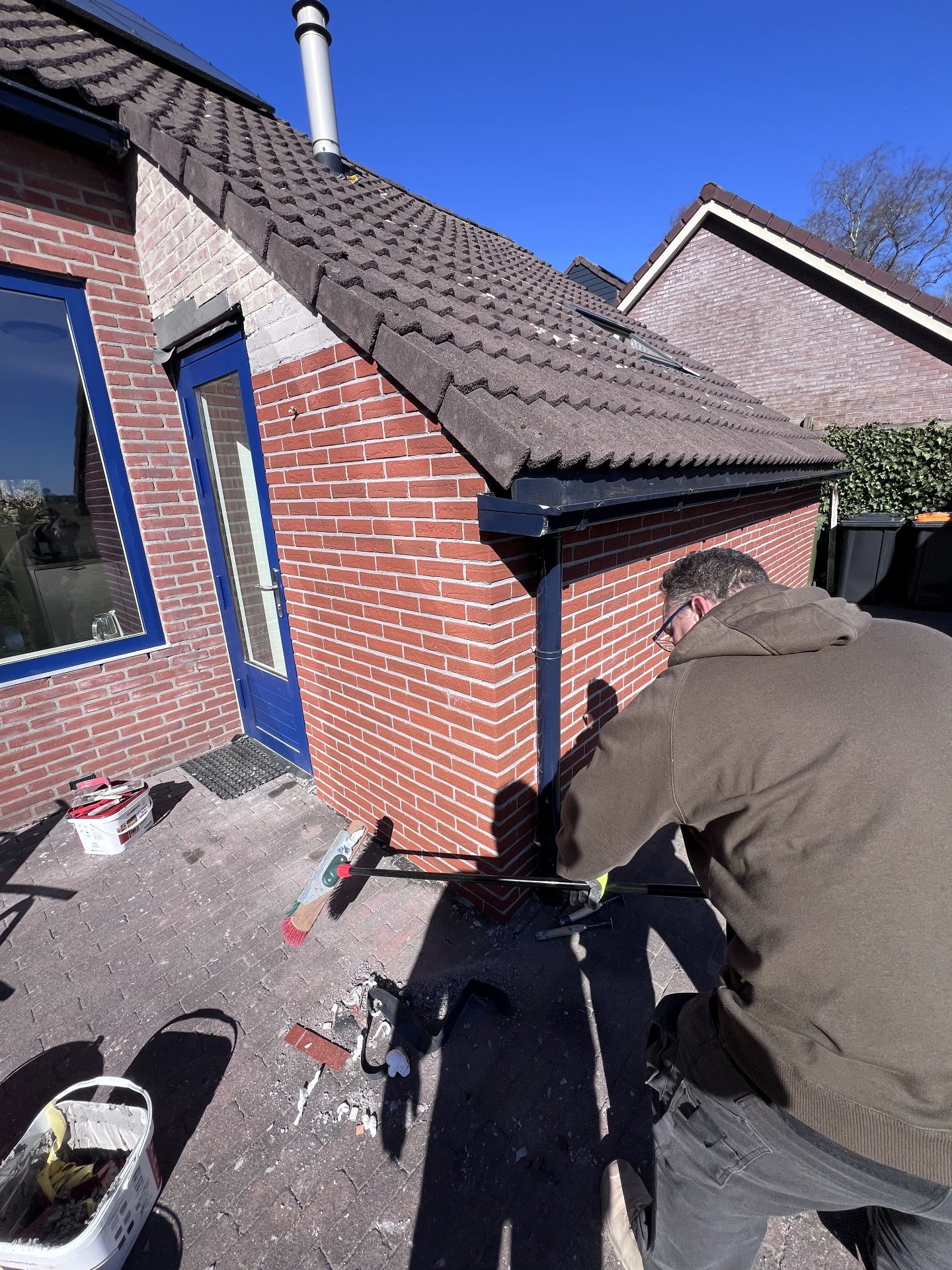 René aan het werk met steenstrips op de gevel