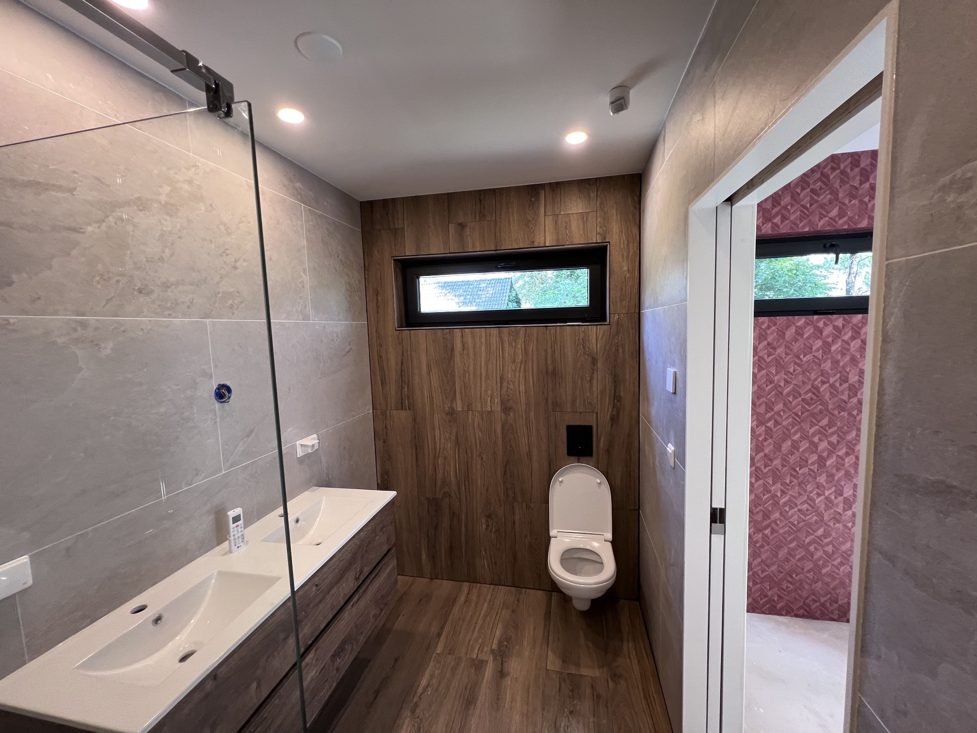 Nieuwe badkamer met dubbele wastafel, inloopdouche en houtlook tegels